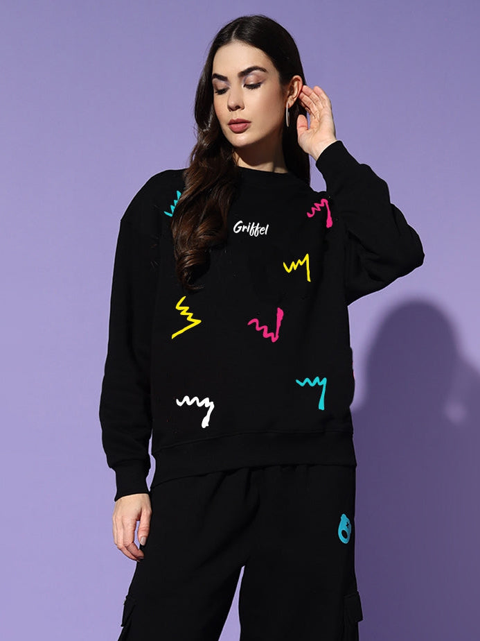 Woman wearing a black outfit with colorful graphics on a purple background