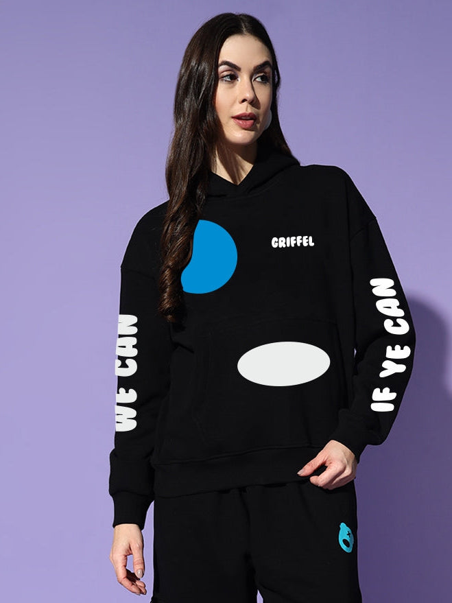 Woman wearing a black hoodie and pants with text and graphics on a purple background