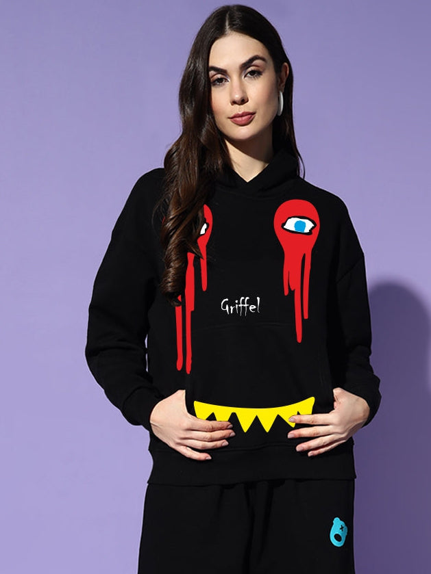 Person wearing a black hoodie with red and yellow design on a purple background